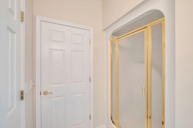 bathroom featuring a shower with door