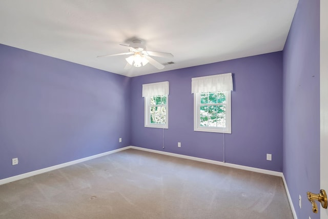 carpeted spare room featuring ceiling fan