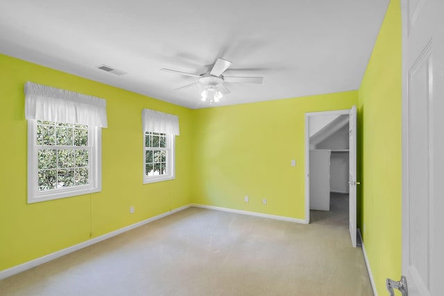 spare room with ceiling fan and light carpet