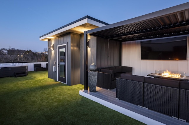 exterior space with a wooden deck, a hot tub, a yard, and an outdoor living space with a fire pit