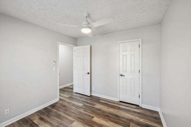 interior space with a textured ceiling, ceiling fan, and dark hardwood / wood-style flooring