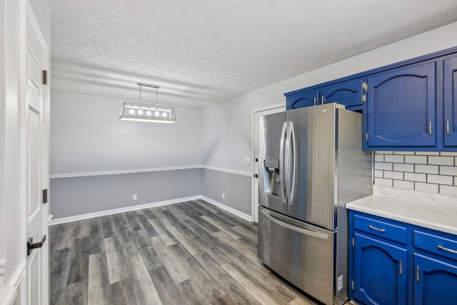 kitchen with stainless steel fridge with ice dispenser, decorative backsplash, blue cabinets, wood-type flooring, and a textured ceiling