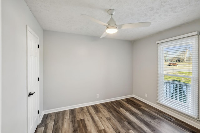 empty room featuring ceiling fan, dark hardwood / wood-style floors, and a textured ceiling