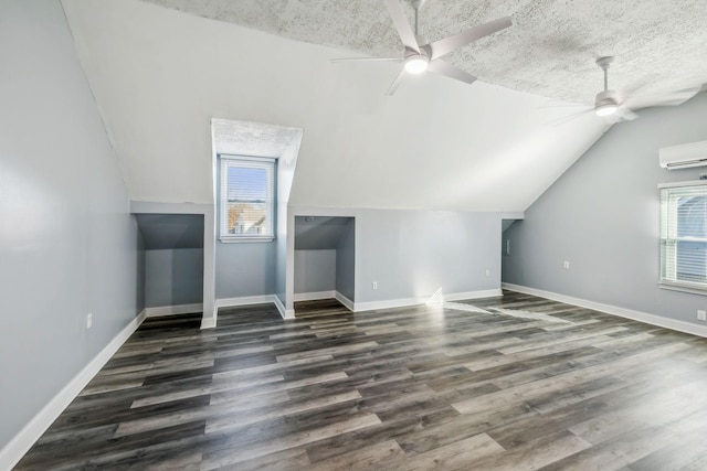 bonus room with a healthy amount of sunlight, vaulted ceiling, dark wood-type flooring, and a wall mounted air conditioner