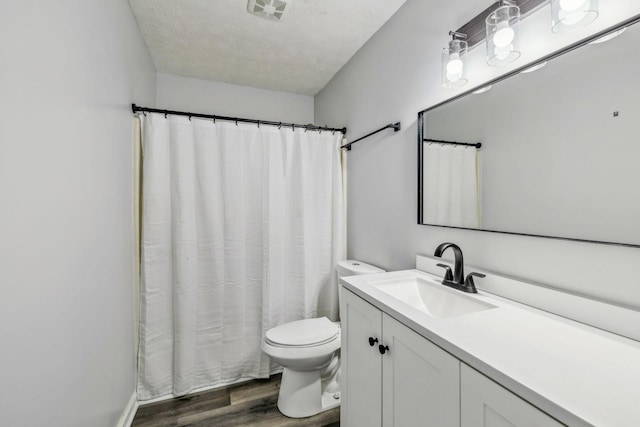 bathroom featuring toilet, vanity, a textured ceiling, and hardwood / wood-style floors