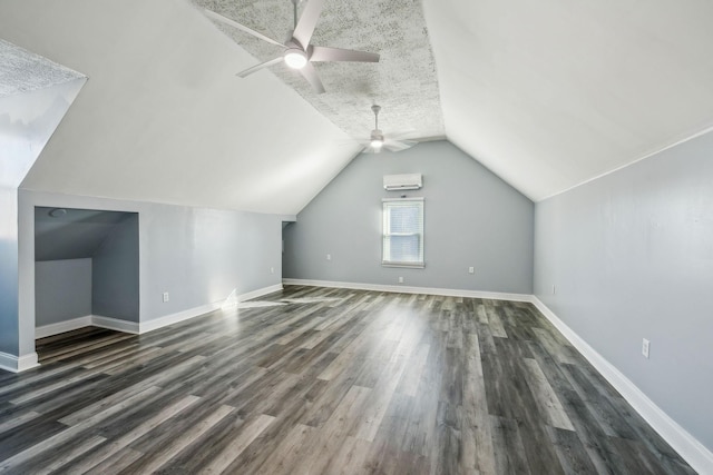 bonus room featuring ceiling fan, dark hardwood / wood-style floors, a textured ceiling, vaulted ceiling, and an AC wall unit