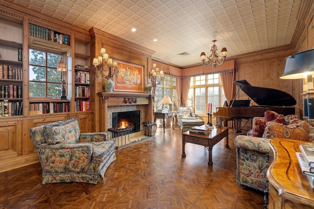 living room featuring a high end fireplace, built in shelves, ornamental molding, wood walls, and dark parquet floors