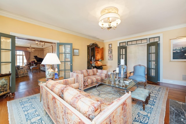 living room featuring dark hardwood / wood-style flooring, ornamental molding, french doors, and an inviting chandelier