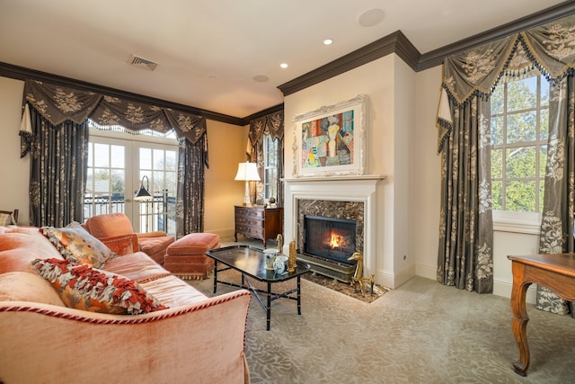 living room with plenty of natural light, carpet, a high end fireplace, and ornamental molding