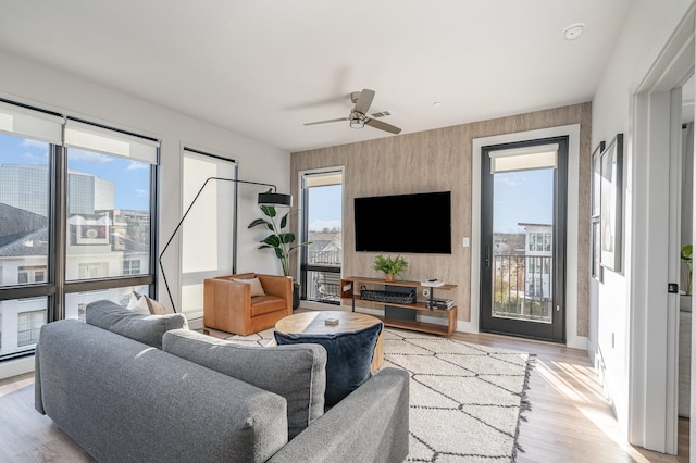 living room with ceiling fan, a baseboard radiator, and light hardwood / wood-style flooring