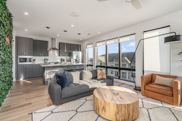 living room featuring ceiling fan and light hardwood / wood-style floors