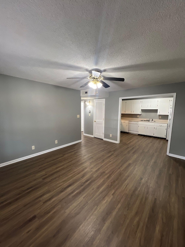 unfurnished living room featuring ceiling fan, dark hardwood / wood-style flooring, sink, and a textured ceiling