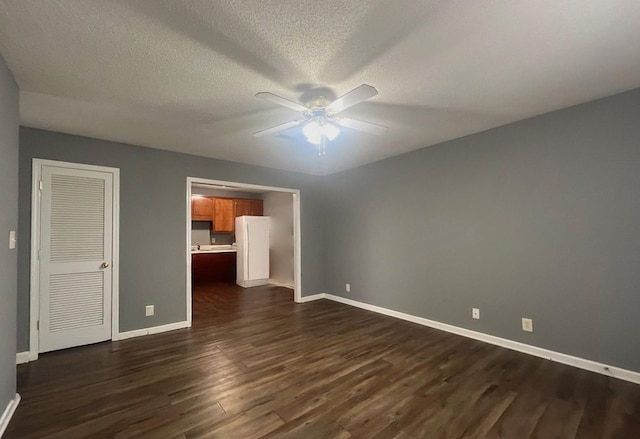 unfurnished bedroom with ceiling fan, dark wood-type flooring, and a textured ceiling