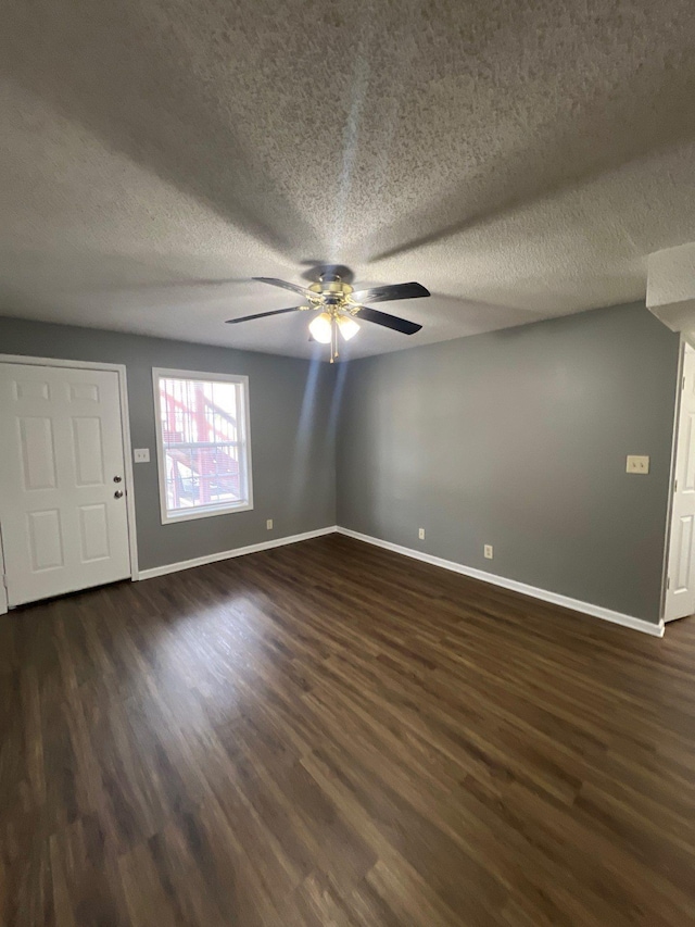 unfurnished room featuring ceiling fan, a textured ceiling, and dark hardwood / wood-style floors