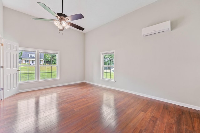 empty room with ceiling fan, hardwood / wood-style flooring, and a wall unit AC