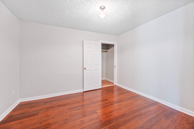 unfurnished bedroom with wood-type flooring and a textured ceiling