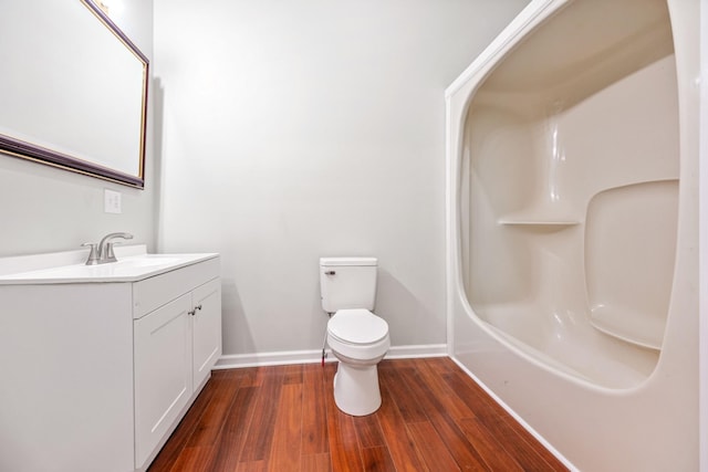 bathroom with toilet, vanity, and hardwood / wood-style flooring