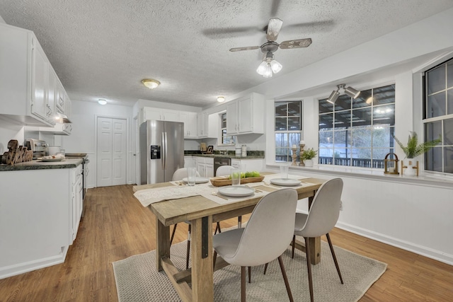 dining room with ceiling fan, a textured ceiling, and hardwood / wood-style floors