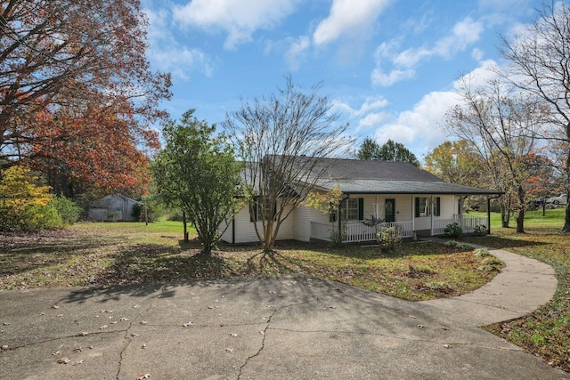 ranch-style house with a shed, a porch, and a front yard