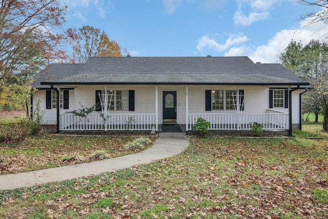 ranch-style home featuring covered porch and a front lawn