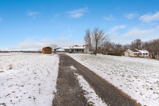 yard covered in snow featuring a storage shed