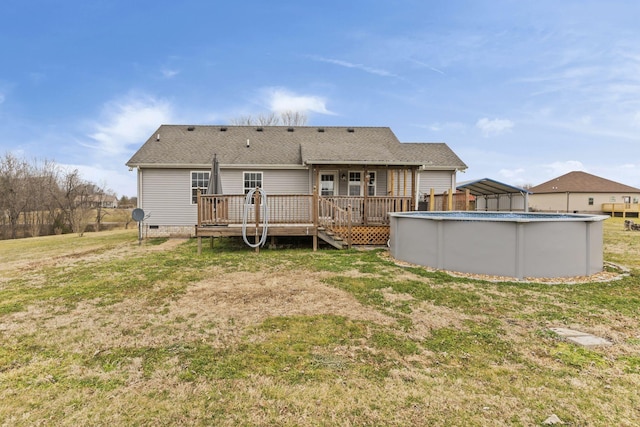 rear view of property with a pool side deck and a yard