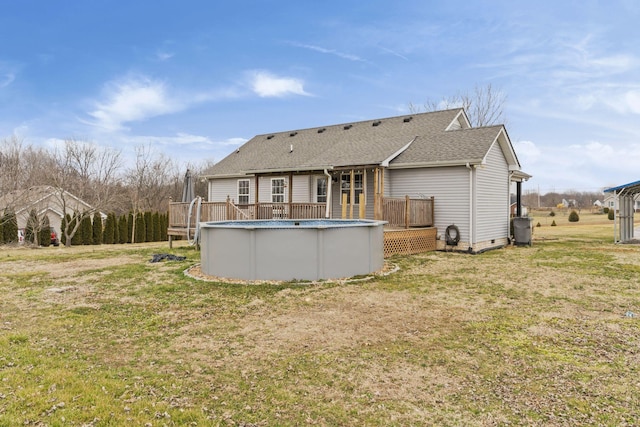 rear view of house featuring a swimming pool side deck and a yard