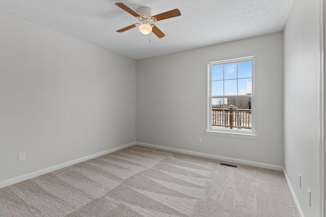 carpeted empty room featuring ceiling fan and a textured ceiling