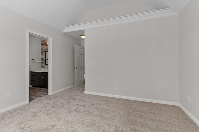 spare room with light carpet, vaulted ceiling, and a textured ceiling