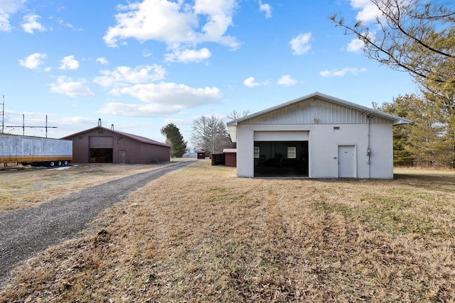 view of outdoor structure featuring a garage and a lawn