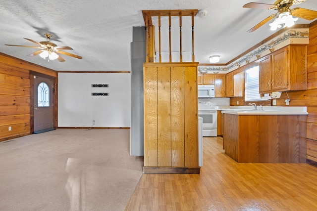 kitchen featuring white appliances, a textured ceiling, light hardwood / wood-style flooring, kitchen peninsula, and ceiling fan