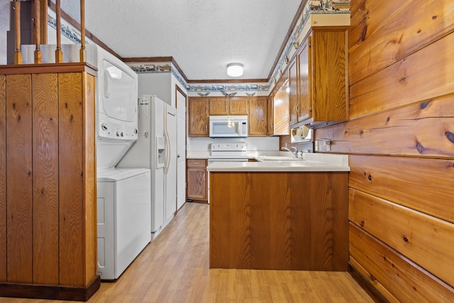 kitchen with sink, white appliances, ornamental molding, light hardwood / wood-style floors, and a textured ceiling