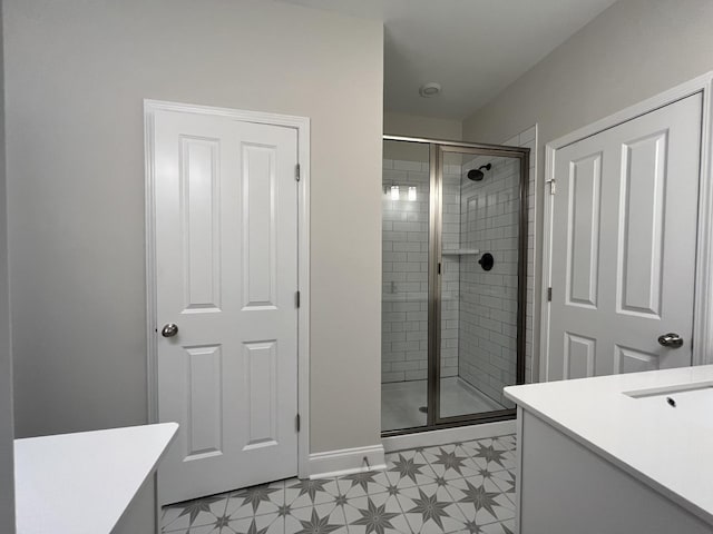 bathroom featuring a shower with door and vanity