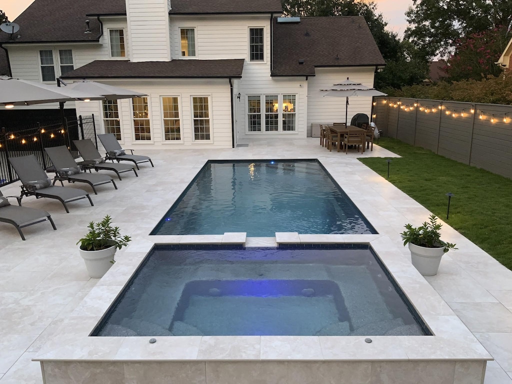 view of swimming pool featuring a patio area and an in ground hot tub