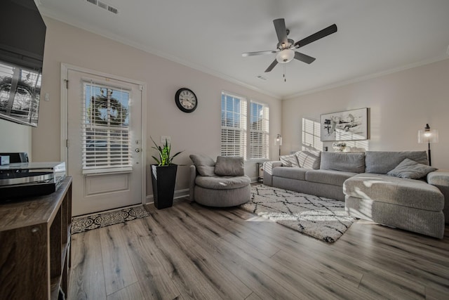 living room with crown molding, ceiling fan, and light hardwood / wood-style floors