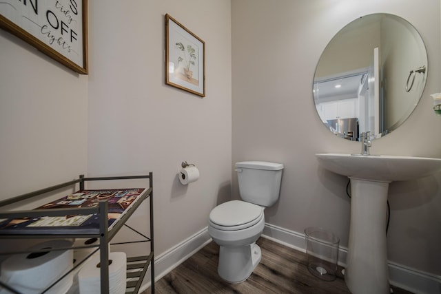 bathroom with sink, hardwood / wood-style floors, and toilet