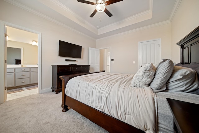 bedroom featuring crown molding, ceiling fan, ensuite bathroom, light carpet, and a raised ceiling