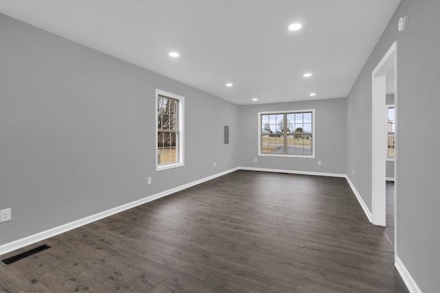 unfurnished room featuring dark hardwood / wood-style flooring and electric panel