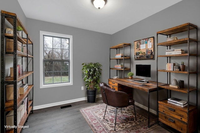 office with dark hardwood / wood-style floors and plenty of natural light