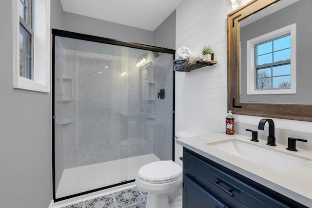 bathroom with tile patterned floors, toilet, a shower with door, and vanity