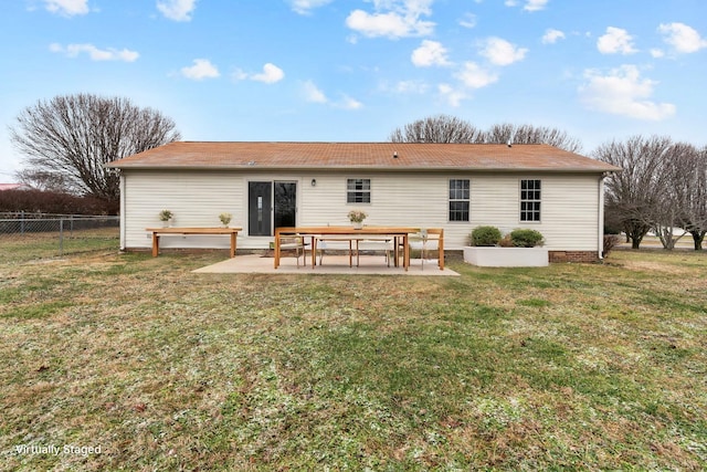 back of house with a lawn and a patio