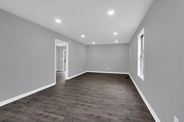 unfurnished room featuring dark wood-type flooring and plenty of natural light