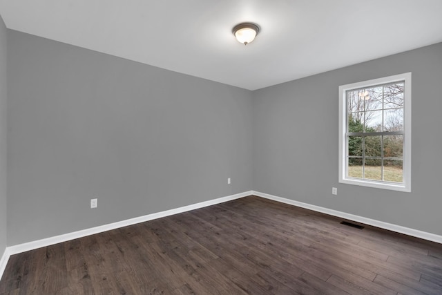 spare room with dark hardwood / wood-style flooring