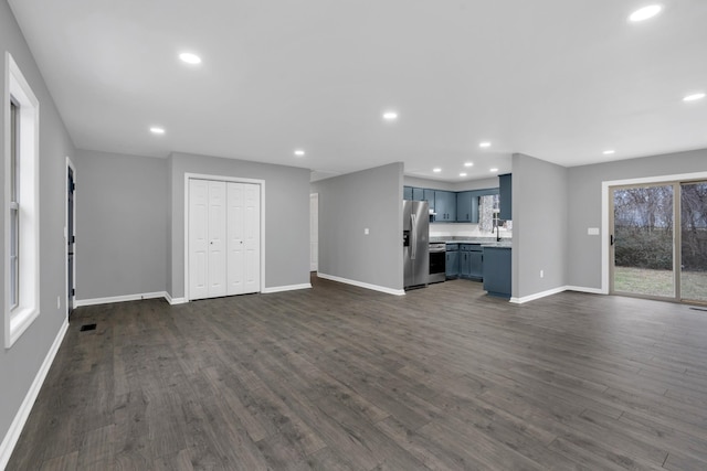 unfurnished living room with dark wood-type flooring and sink