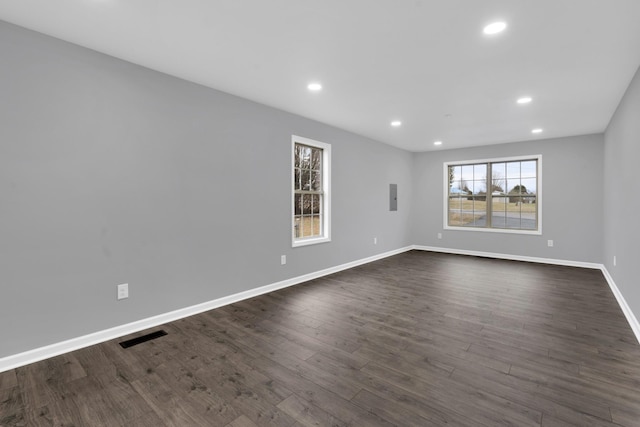 empty room featuring electric panel and dark hardwood / wood-style floors