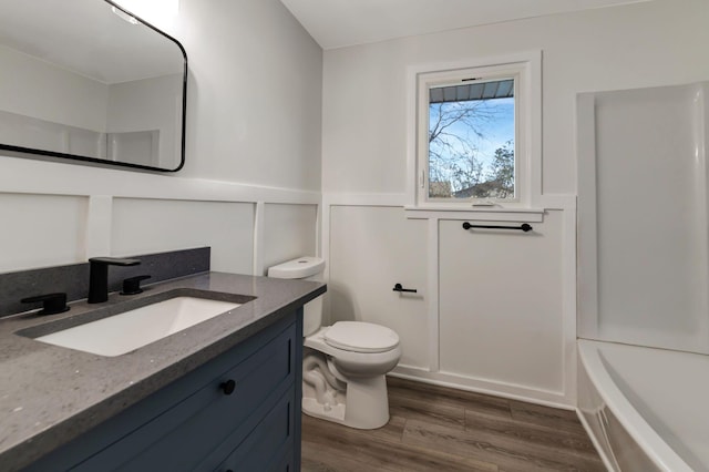 bathroom with toilet, vanity, and hardwood / wood-style floors