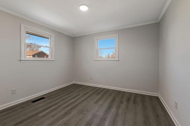 empty room with dark wood-type flooring, ornamental molding, and a healthy amount of sunlight