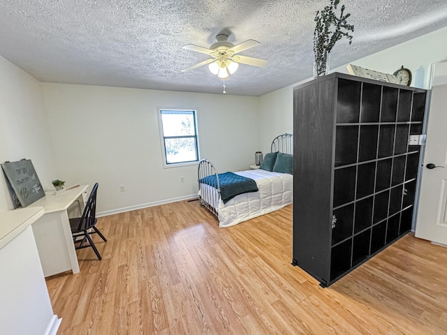 bedroom featuring hardwood / wood-style flooring, a textured ceiling, and ceiling fan