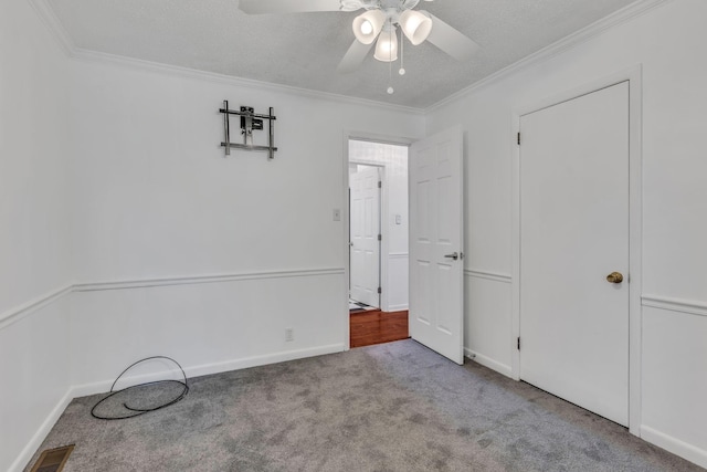 unfurnished bedroom with ceiling fan, crown molding, light carpet, and a textured ceiling