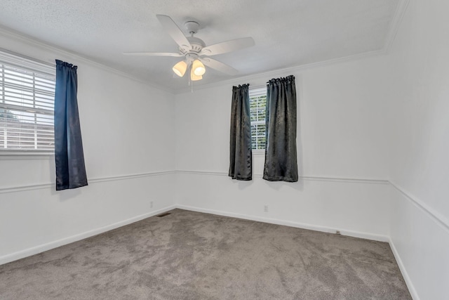 spare room with ceiling fan, crown molding, and light carpet